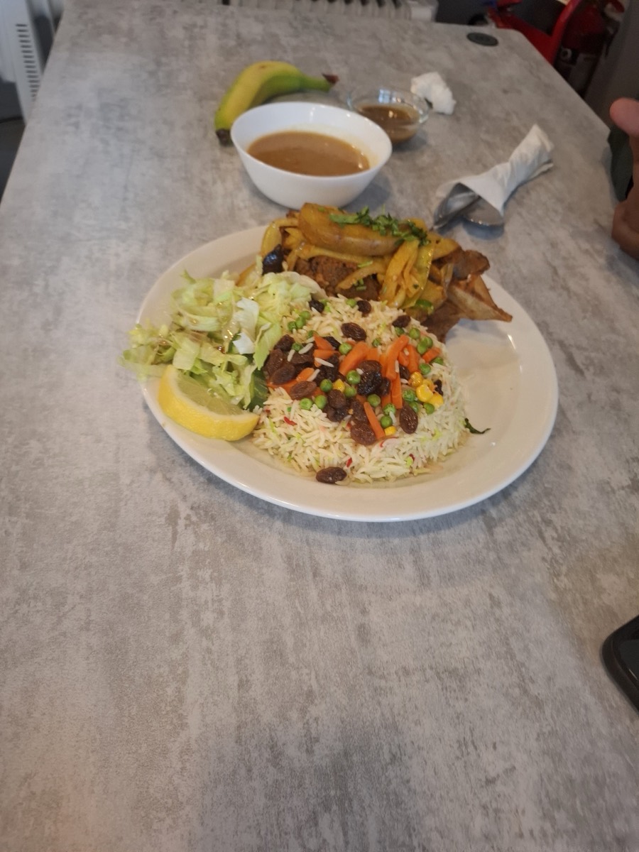 A Somali plate at Nafsoor — spiced vegetable rice with lamb, fried plantain, salad and soup
